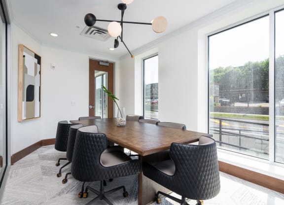 Work from home conference style room with large rectangle table and rolling chairs surrounding the table.