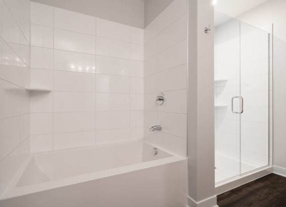 Bathroom with bath tub and walk in glass shower to the right
