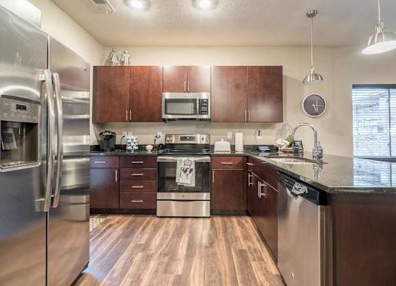 A kitchen with wooden floors and stainless steel appliances.