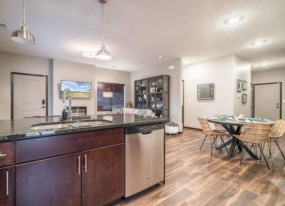 A kitchen with dark wood cabinets and a black countertop.