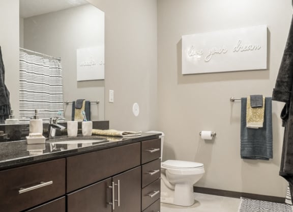 Interiors-Bathroom in traditional design scheme with dark cabinetry, light tile floors and granite countertops