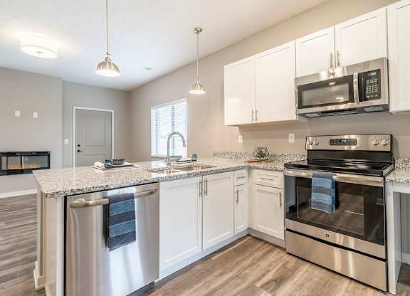 Apartment kitchen with white cabinets and stainless steel appliances