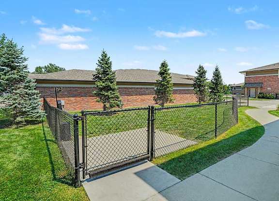 A black metal fence surrounds a green lawn.