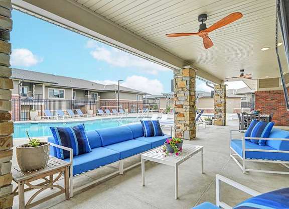 A patio with a pool and a blue couch.