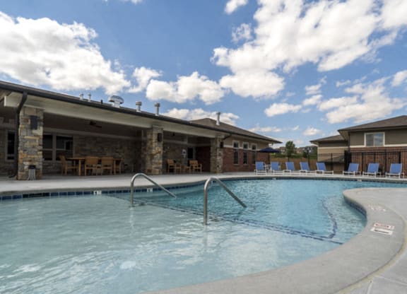 Resort-style pool with lounge seating at The Villas at Falling Waters townhomes for rent in West Omaha NE