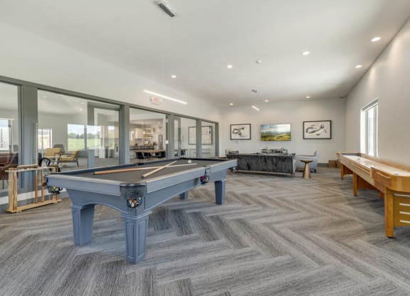 Large game room including TVs, pool tables, and shuffle board at The Villas at Mahoney Park