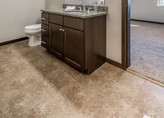 Upscale bathroom with granite countertops and attached walk in closet at the Villas at Wilderness Ridge in Lincoln Nebraska