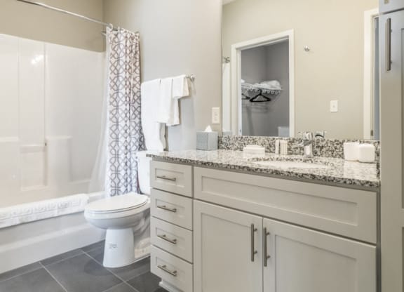 Bathroom with granite counter tops and gray slate flooring at The Villas at Mahoney Park