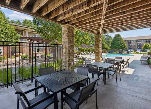 Covered patio amenity at Villas of Omaha at Butler Ridge with outdoor tables and chairs overlooking the community pool.