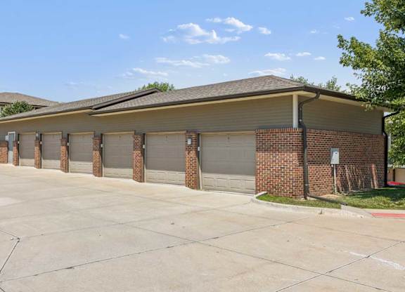 Detached garage building at Villas of Omaha at Butler Ridge with multiple individual garage doors and brick exterior.