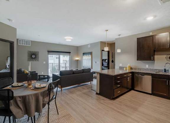 A modern kitchen with dark wood cabinets and a dining table set for two