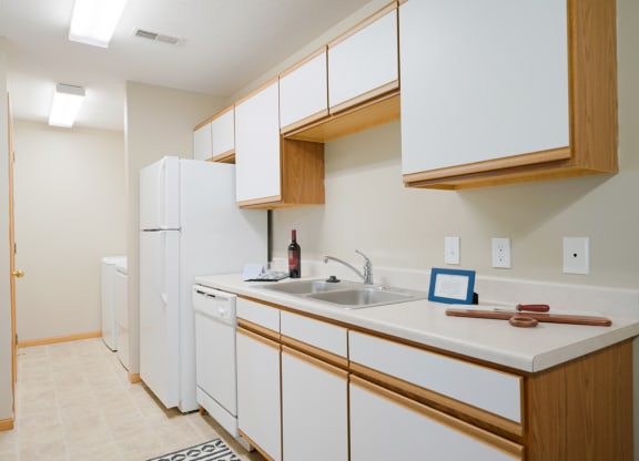 Traditional kitchen with white cabinets, a dishwasher, a sink and a refrigerator