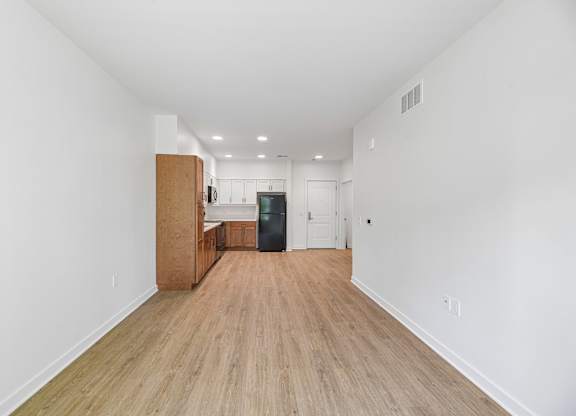 A long hallway with wood floors and white walls.
