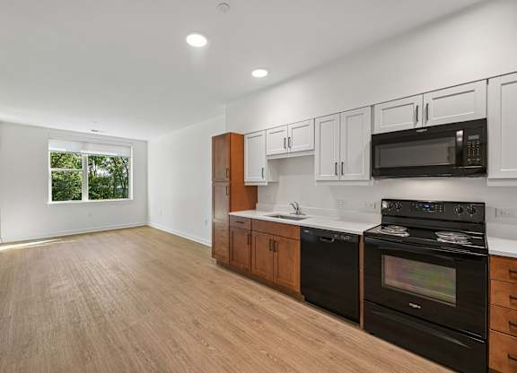 A kitchen with black appliances and wooden cabinets.
