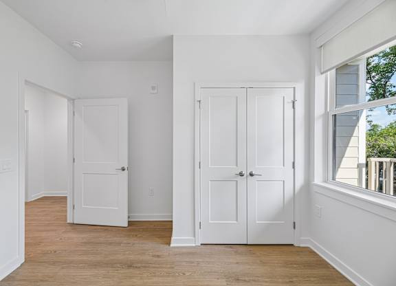A white room with two doors and a window.