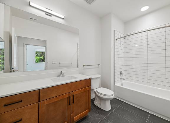 A white bathroom with a toilet, sink, and bathtub.