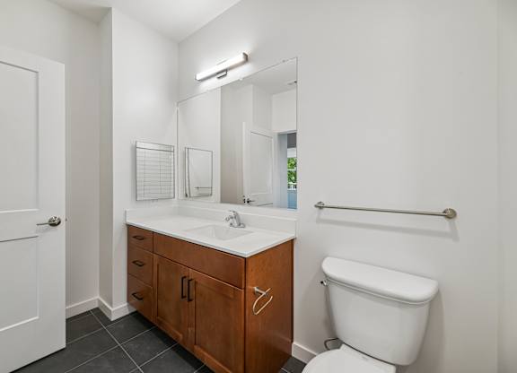 A white bathroom with a toilet, sink, and mirror.
