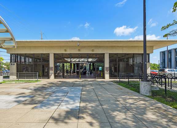 A sunny day at the entrance of a modern building with a glass roof.