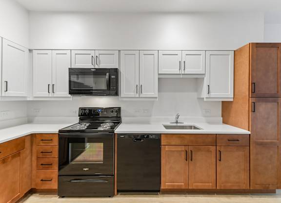 A kitchen with black appliances and wooden cabinets.