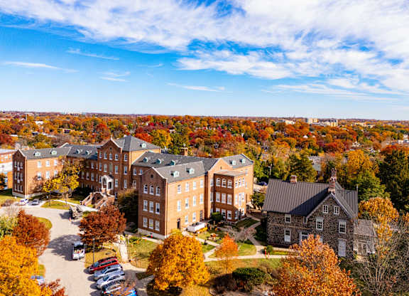 A large building complex surrounded by trees with autumn leaves.