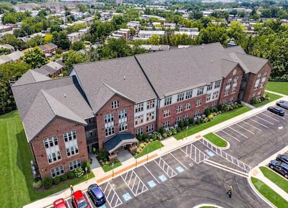 A large red brick building with a parking lot in front.