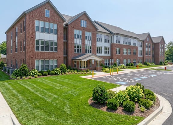 A large red brick building with a parking lot in front.