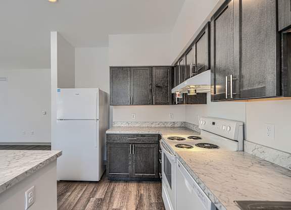 A kitchen with a white fridge and black cabinets.
