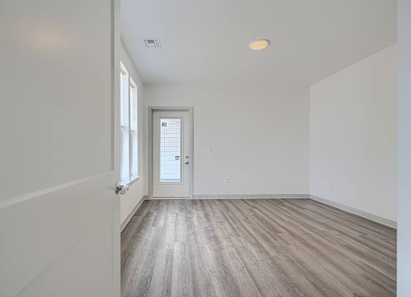 A room with a wooden floor and a white door.