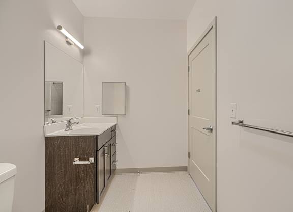 A bathroom with a sink, mirror, and toilet.