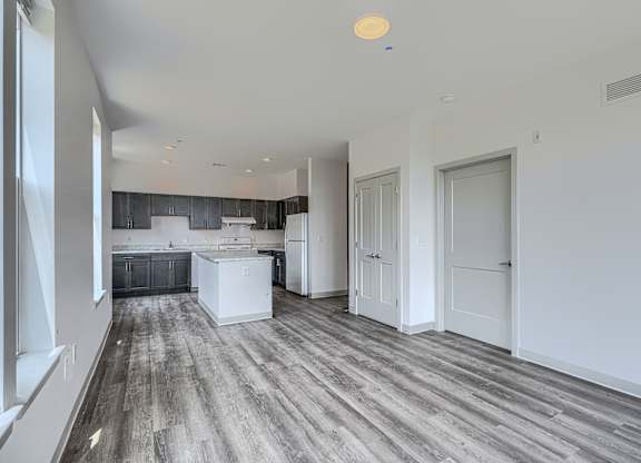 A spacious kitchen with white cabinets and a large island.