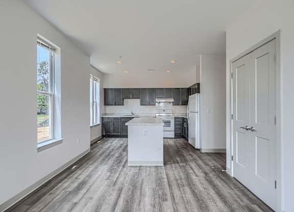 A kitchen with a white island in the middle of the room.