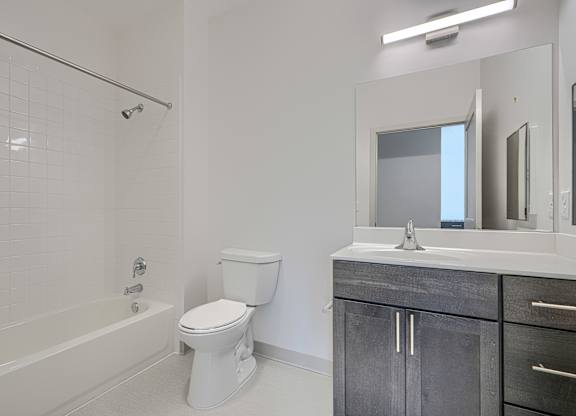 A white bathroom with a toilet, sink, and bathtub.