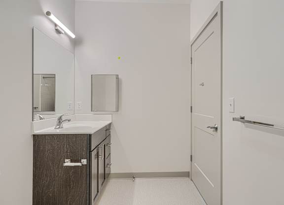 A bathroom with a sink, mirror, and medicine cabinet.