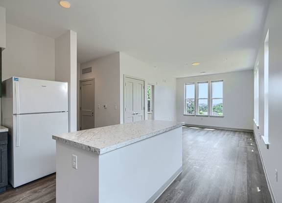 A kitchen with white appliances and cabinets is shown.