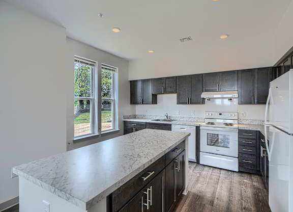 A kitchen with a marble countertop and stainless steel appliances.
