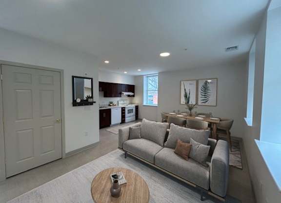 A living room with a grey couch and a wooden coffee table.