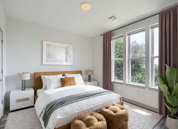 A bedroom with a large bed and a painting on the wall.