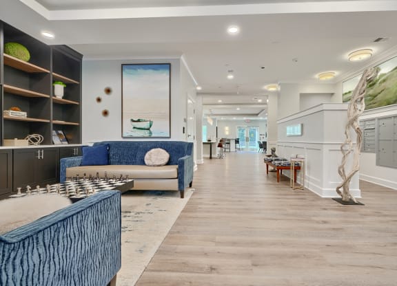 a long living room with blue couches and a table