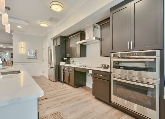 a kitchen with stainless steel appliances and wooden floors