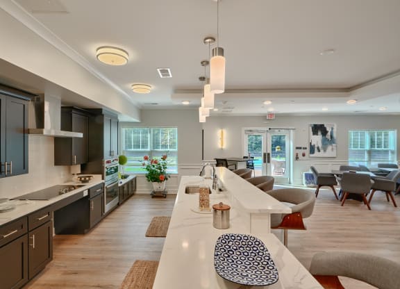 an open kitchen and living room with a long white counter top