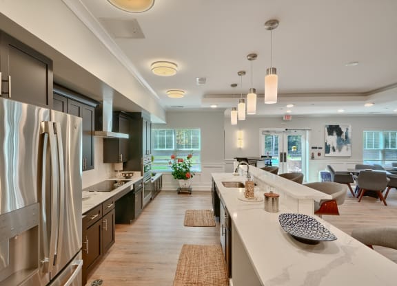 an open kitchen and living room with a large island and stainless steel appliances