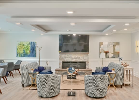 a living room with chairs and a table and a fireplace