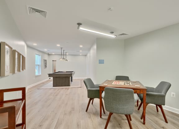 a game room with a table and chairs and a billiards table