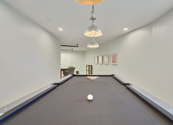 a billiards room with a pool table and two ceiling lights