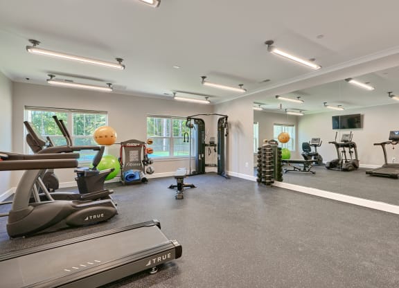 a gym with treadmills and other exercise equipment in a building with windows