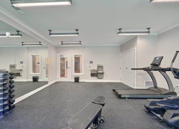 an empty gym with exercise equipment and dumbbells