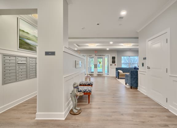 a long hallway with white walls and white closets and white doors and a hallway