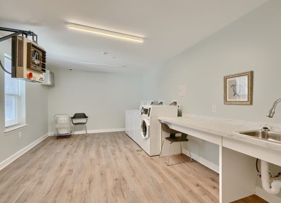 a laundry room with a sink and a washer and dryer in a room