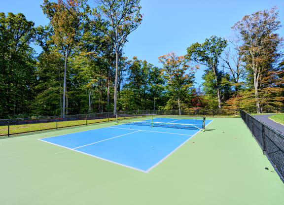 a tennis court with blue and green asphalt on top of it