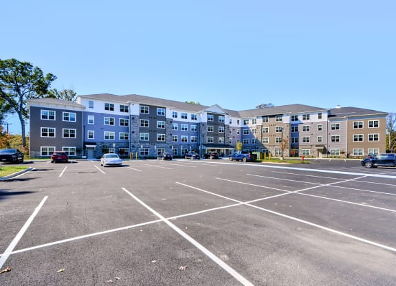 an empty parking lot in front of an apartment building